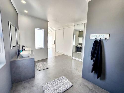 a large bathroom with a sink and a mirror at Treasure in St Helena Bay