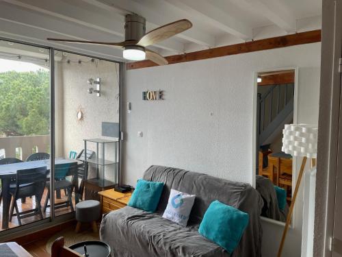 un salon avec un canapé et un ventilateur de plafond dans l'établissement Plein Sud By Bellavista - 400 m de la plage - terrasse - parking, à Argelès-sur-Mer