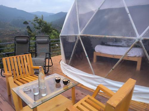 a gazebo with two chairs and a table with two glasses at L.T NATURE GLAMPS in Kodaikānāl