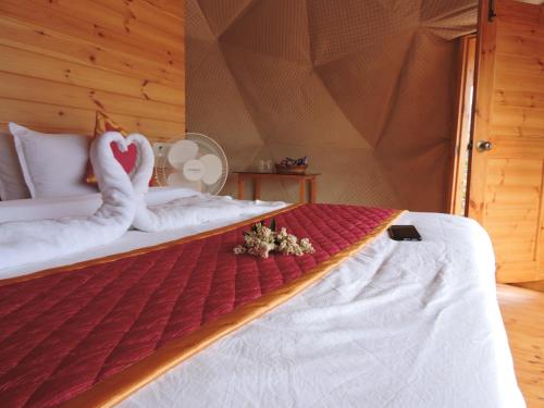 a bedroom with a bed with a swan made out of towels at L.T NATURE GLAMPS in Kodaikānāl