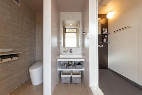 ein Badezimmer mit einem WC, einem Waschbecken und einem Spiegel in der Unterkunft villa vacances hamanako - Vacation STAY 43854v in Hamamatsu