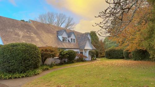 a white house with a roof with a yard at 5Rooms life-style in City—“Golden Harvest Retreat” in Matangi