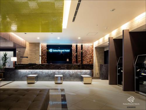 a lobby of a hotel with two stools and a television at Daiwa Roynet Hotel Chiba Ekimae in Chiba