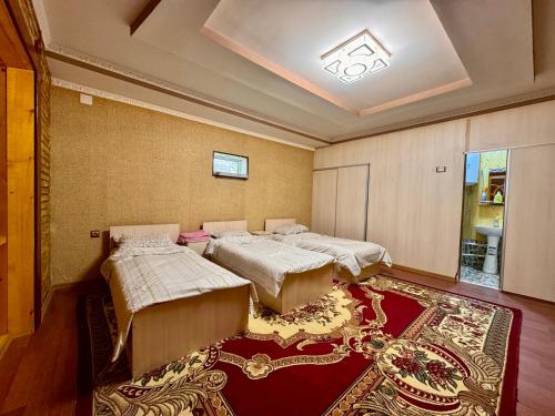 a room with three beds and a rug at Panjrud guest house in Panjakent