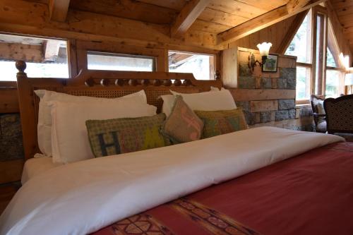 a large bed in a room with wooden ceilings at Kudrat - A Boutique Homestay- Tirthan Valley in Banjār