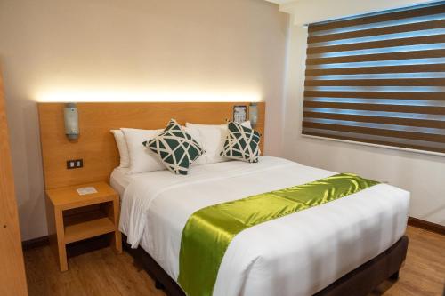 a bedroom with a large white bed with a window at ALVEA HOTEL in Puerto Princesa City