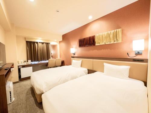 大阪市にあるホテルフクラシア大阪ベイのベッド2台とテレビが備わるホテルルームです。