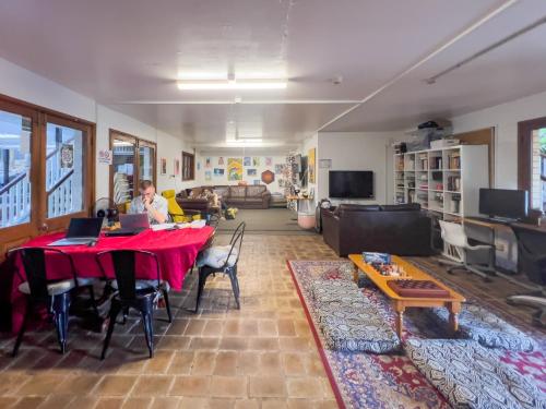 a woman sitting at a table in a living room at Somewhere To Stay Backpackers in Brisbane