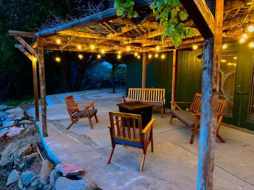 a patio with chairs and a pergola with lights at Emerald Ranch of Yosemite in Coarsegold