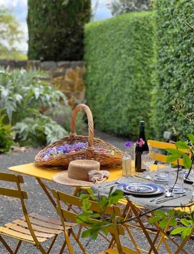 a picnic table with a basket and a hat on it at Honeysuckle Barn & Garden in Kyneton