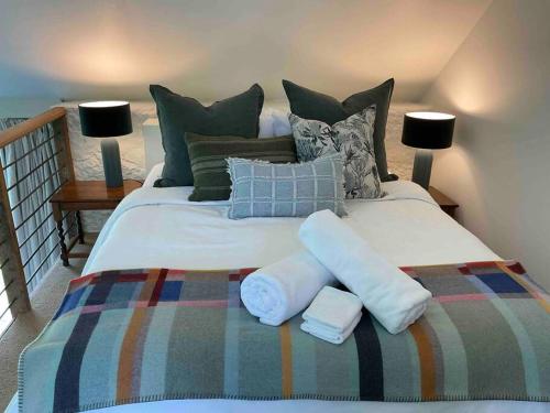 a large white bed with pillows and towels on it at Honeysuckle Barn & Garden in Kyneton