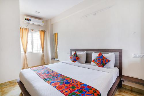 ein Schlafzimmer mit einem großen Bett mit einer bunten Decke in der Unterkunft FabExpress MS Comforts in Bangalore