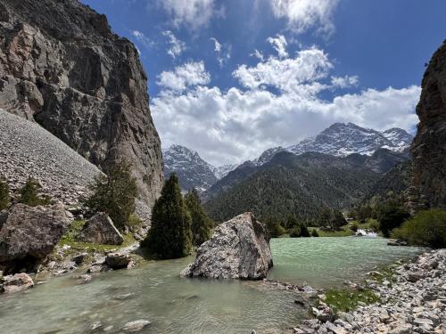 um rio nas montanhas com pedras na água em Mountain Base ARTUCH em Panjakent
