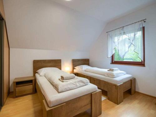 Dos camas en una habitación con ventana. en Claudia Comfortable holiday residence, en Łukęcin