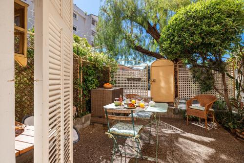 un petit jardin avec une table avec des fruits dessus dans l'établissement Les Orangers - Happy Rentals, à Beaulieu-sur-Mer