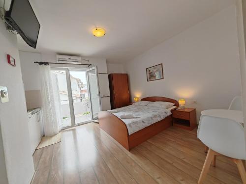 a bedroom with a bed and a large window at Apartments & Rooms Samohod in Vodice