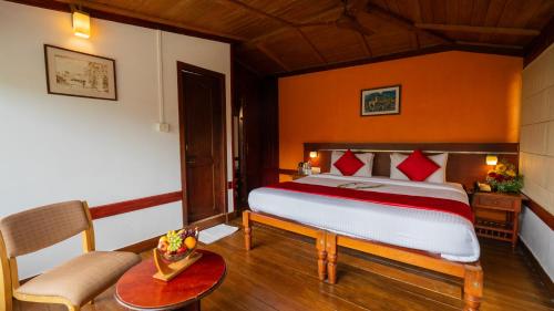 a bedroom with a bed and a table and a chair at Westwood Riverside in Munnar