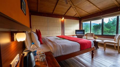 a bedroom with a bed in a room withwindows at Westwood Riverside in Munnar