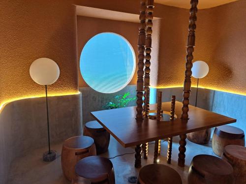a dining room with a wooden table and stools at Mai Hotel Chiang Mai in Chiang Mai