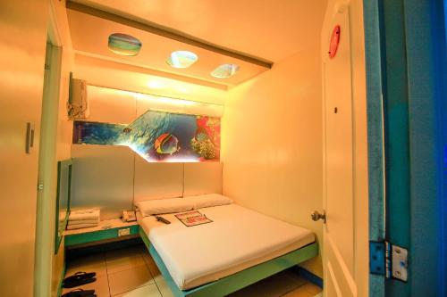 a small room with a small bed in it at Astrotel Monumento in Manila