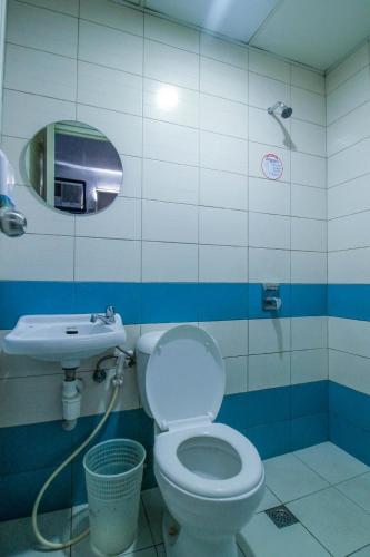 a bathroom with a toilet and a sink at Astrotel Monumento in Manila