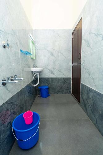 a bathroom with a sink and a toilet and buckets at Rameswaram Amman Residency - Your Budjet-Friendly Stay in Rāmeswaram