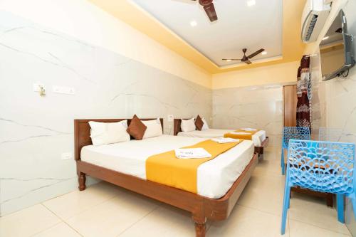 a bedroom with a bed and a blue chair at Hotel Amman Residency in Rāmeswaram