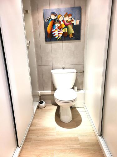 une salle de bain avec toilettes et un tableau au mur dans l'établissement Appartement Duplex 40 M², à Fontenay-Trésigny