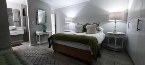 a white bedroom with a bed and a mirror at Fairview 17 Yzerfontein South Africa in Yzerfontein