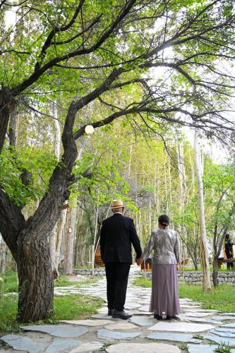 an older man and woman walking down a path at Organic Village Retreat in Hundar