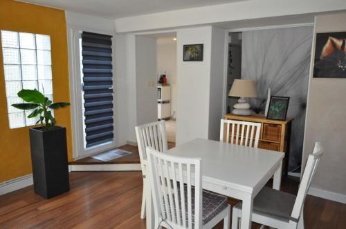 une salle à manger avec une table et des chaises blanches dans l'établissement L'Erable, à Marseille
