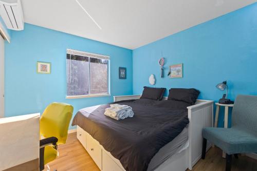 a blue bedroom with a bed and a chair at HotTub PingPong Arcade Billiard Pets AC Piano BBQ Art in Twain Harte