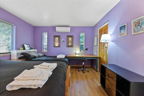 a purple room with two beds and a desk at HotTub PingPong Arcade Billiard Pets AC Piano BBQ Art in Twain Harte
