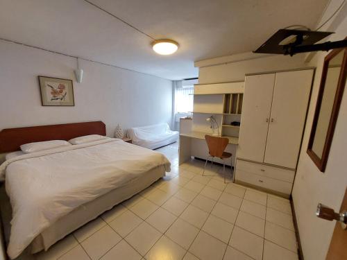 een slaapkamer met een wit bed en een kast bij Baan Sathorn 21 in Yan Nawa