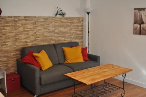 - un salon avec un canapé gris et des oreillers colorés dans l'établissement L'Erable, à Marseille