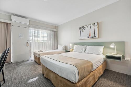 um quarto de hotel com duas camas e uma janela em Glenelg Dockside Motel em Adelaide