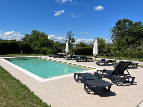 uma piscina com cadeiras e guarda-sóis ao lado em Villa Orka em Labin