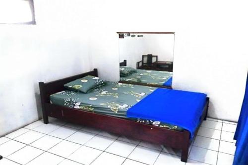 een bed in een kamer met een spiegel bij Kalingga Sekar in Yogyakarta