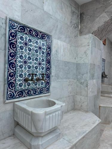 a bathroom with a tub and a rug on the wall at Century Cave Hotel in Goreme