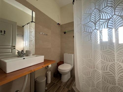 bagno con lavandino bianco e servizi igienici di Olivia Studios - Melina's home near the sea a Agia Triada
