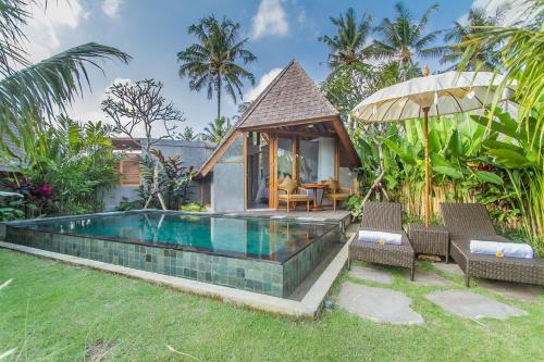 a villa with a swimming pool in a garden at Lasamana Villas Ubud by Pramana Villas in Ubud