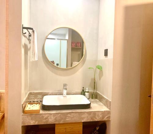 a bathroom with a sink and a mirror at Meadow Lodge Hotel Taizhou in Taizhou