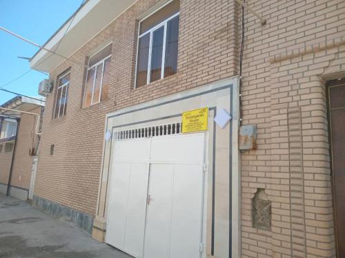 a white garage door on a brick building at Suzangaran House in Samarkand