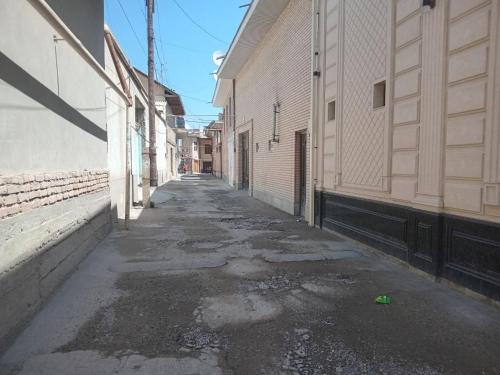 an empty alleyway between two buildings on a street at Suzangaran House in Samarkand