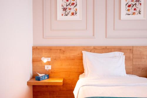 a bedroom with a bed and a wooden headboard at Stil Hotel in Bucharest