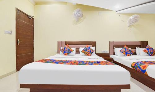 two beds in a room with two beds sidx sidx sidx at FabExpress Poonam Palace in Ahmedabad