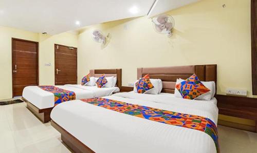 2 Betten in einem Hotelzimmer mit 2 Betten in der Unterkunft FabExpress Poonam Palace in Ahmedabad