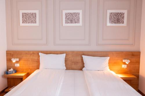 a bed with two white pillows in a room at Stil Hotel in Bucharest