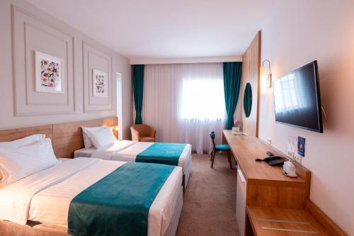 布加勒斯特的住宿－Stil Hotel，酒店客房设有两张床和电视。