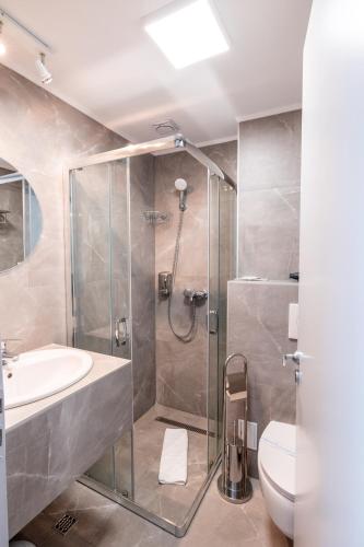 a bathroom with a shower and a sink and a toilet at Stil Hotel in Bucharest